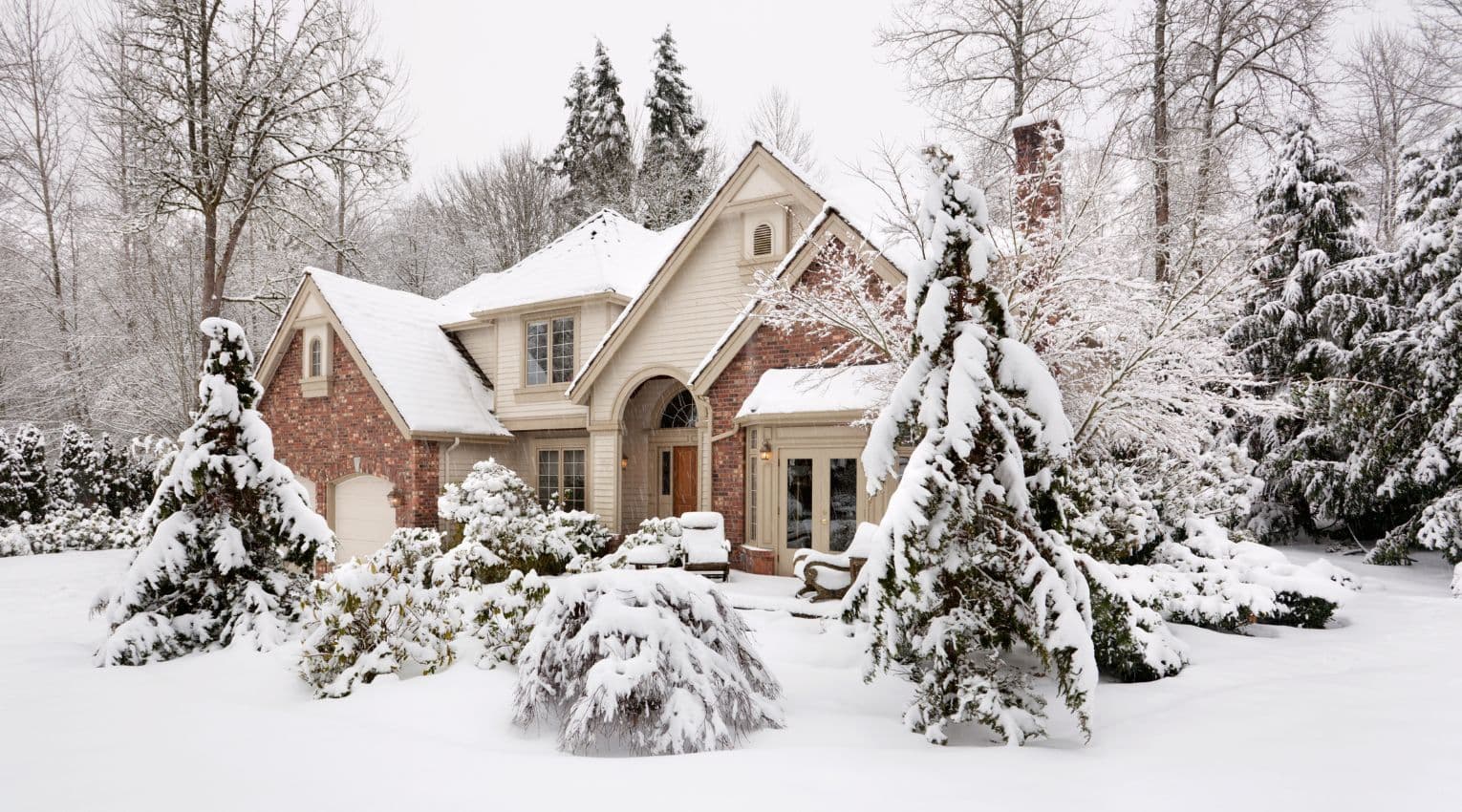 brick home covered in snow